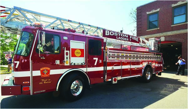 Firefighter Brian McKenna, aided by Firefighter Jeff Scott of Engine 17, backed in a new ladder truck: The Boston Fire Department welcomed four new fire ladders to its fleet on Saturday during an event at the fire house on Meetinghouse Hill. Chris Lovett photo